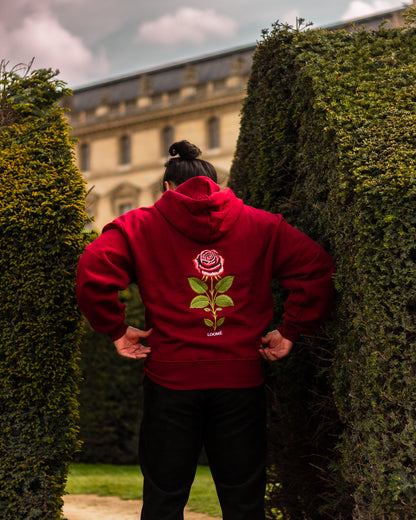 Burgundy rose embroidered hoodie worn outdoors, back embroidery detail
