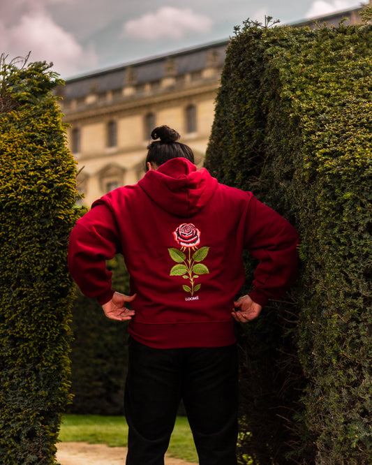 Burgundy rose embroidered hoodie worn outdoors, back embroidery detail